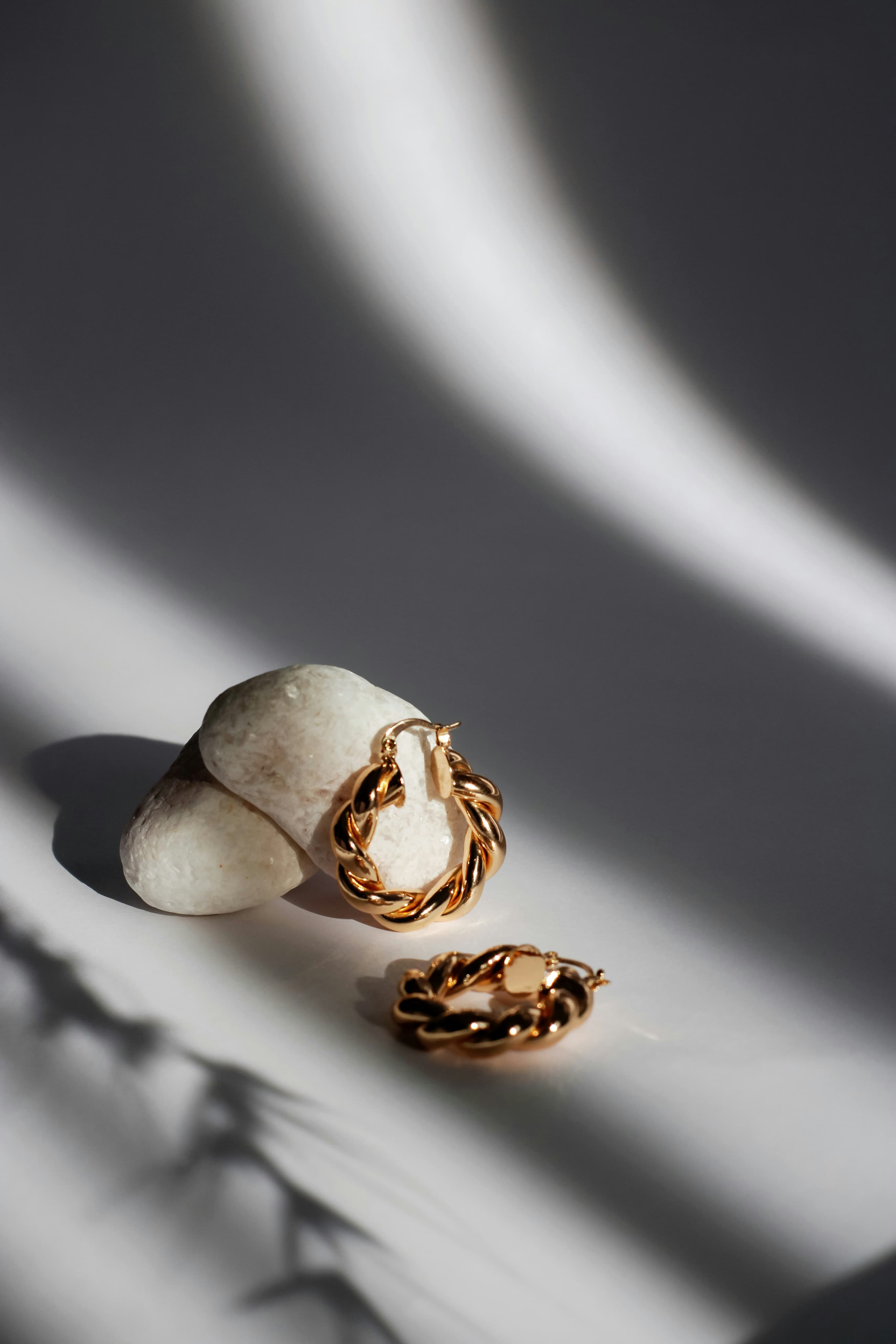 Aros dorados de Aurelia sobre piedras blancas
